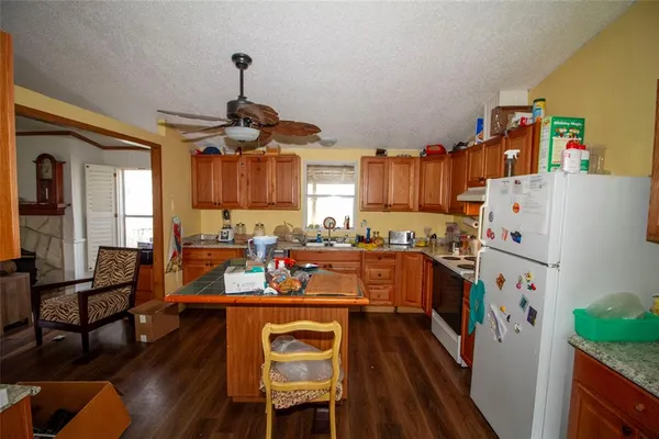 a kitchen with a refrigerator a stove and a dining table with wooden floor