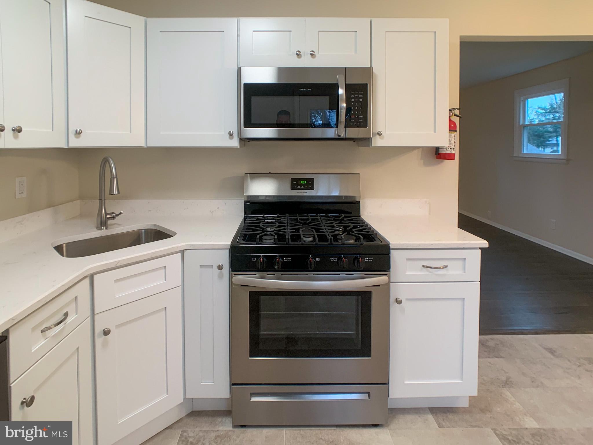 5 Estate Road Pemberton, NJ 08068 - Photo 11 of 25 a kitchen with stainless steel appliances granite countertop white cabinets a stove a sink and dishwasher