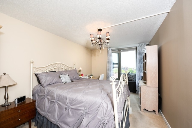 1340 North Dearborn Street, Unit 7D Chicago, IL 60610 - Photo 7 of 17 a bedroom with a large bed and a chandelier