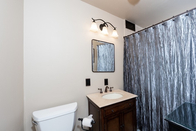 1340 North Dearborn Street, Unit 7D Chicago, IL 60610 - Photo 9 of 17 a bathroom with a toilet a sink and mirror