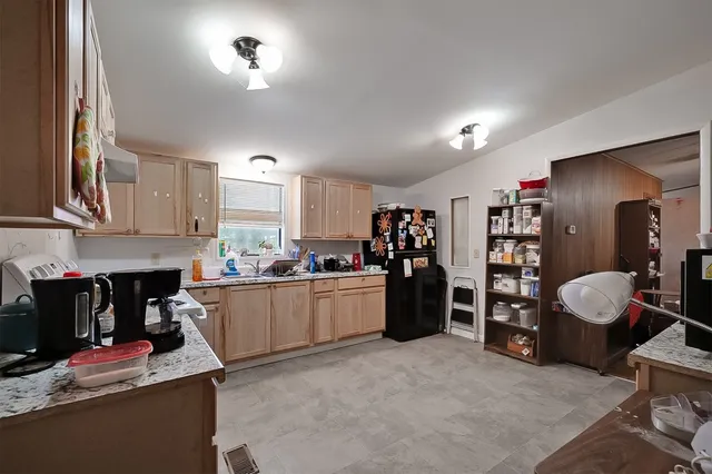 a kitchen with a refrigerator and a stove top oven