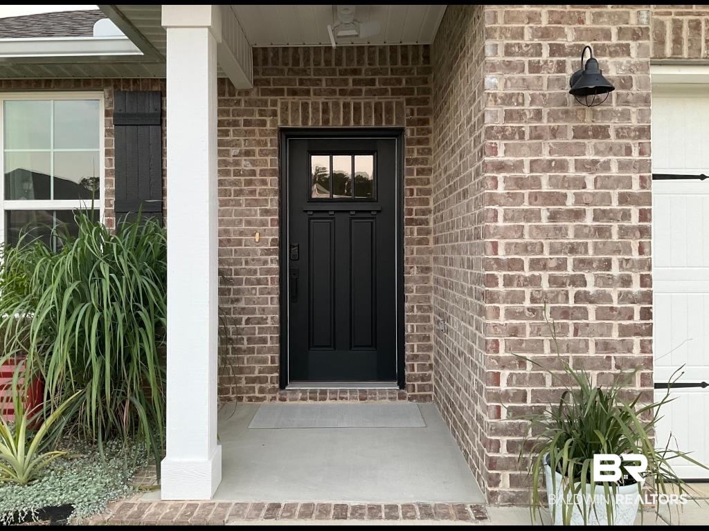 1093 Pheasant Circle Foley, AL 36535 - Photo 2 of 25 View of exterior entry with brick siding and a porch
