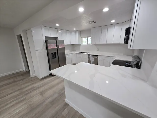 a kitchen with stainless steel appliances a refrigerator sink and microwave