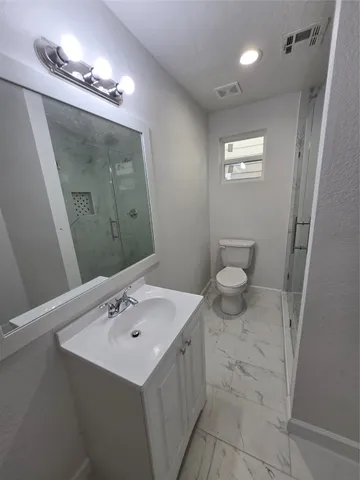 an empty room with a fan & a window