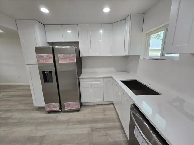a kitchen with white cabinets and white appliances