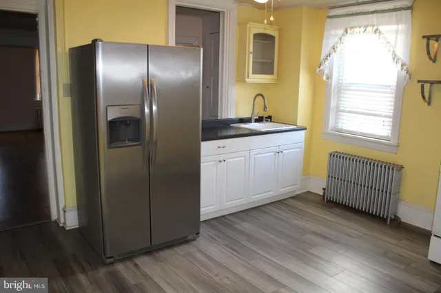 a kitchen with stainless steel appliances granite countertop a refrigerator a sink and dishwasher with wooden floor