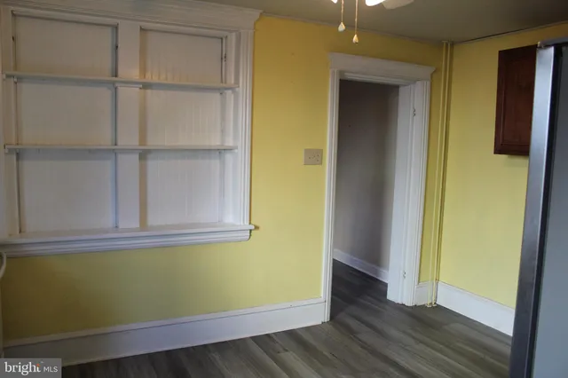a view of a room that has wooden floor and a window