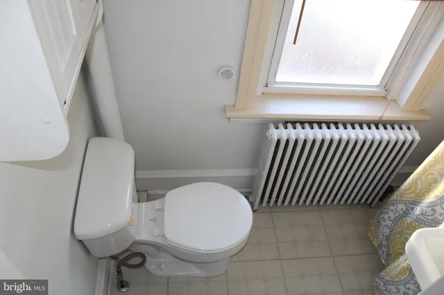 a bathroom with a toilet and a mirror