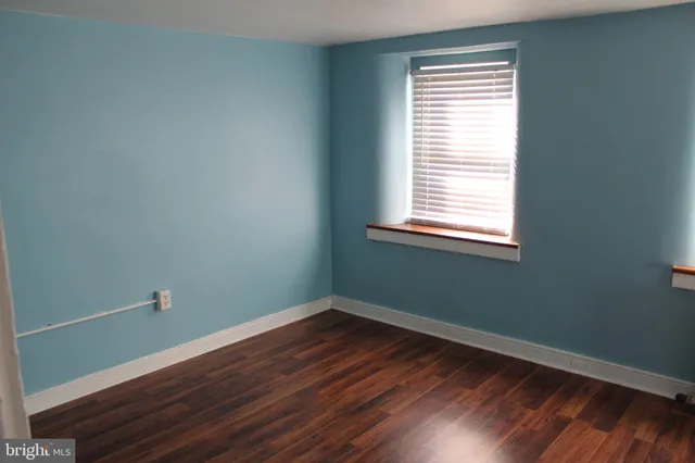 a view of a room with wooden floor and windows