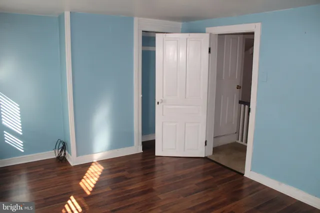 an empty room with wooden floor and closet