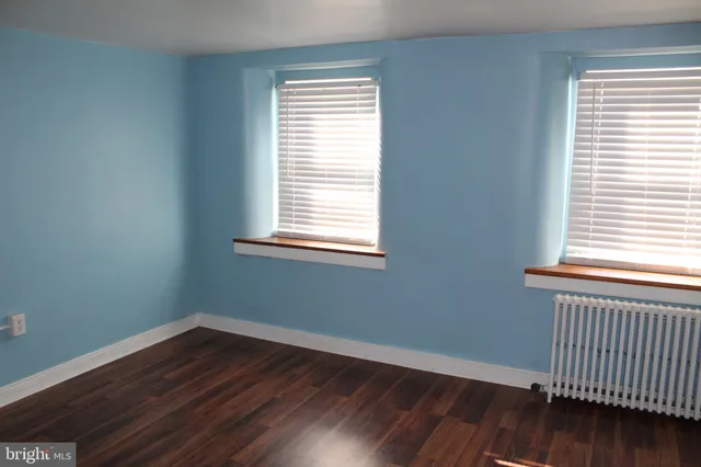a view of a room with wooden floor and a window