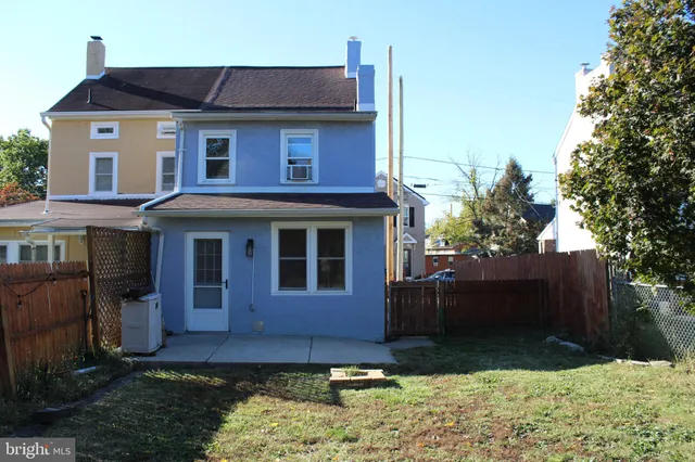 a view of a white house with large windows and a yard
