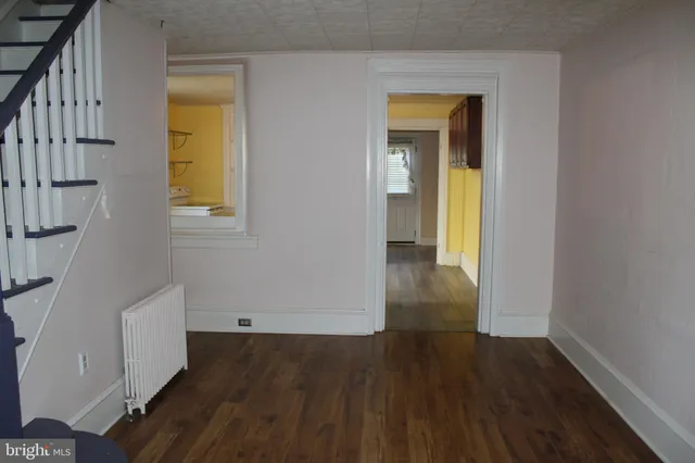 wooden floor in an entryway with a window