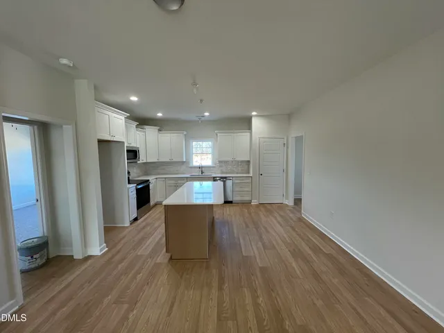 a kitchen with granite countertop white cabinets and black appliances