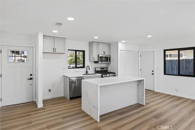 a kitchen with stainless steel appliances a white stove top oven and refrigerator