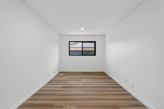 a view of a room with wooden floor and window