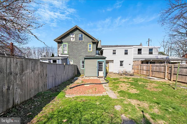 a view of a backyard with table and chairs with wooden fence
