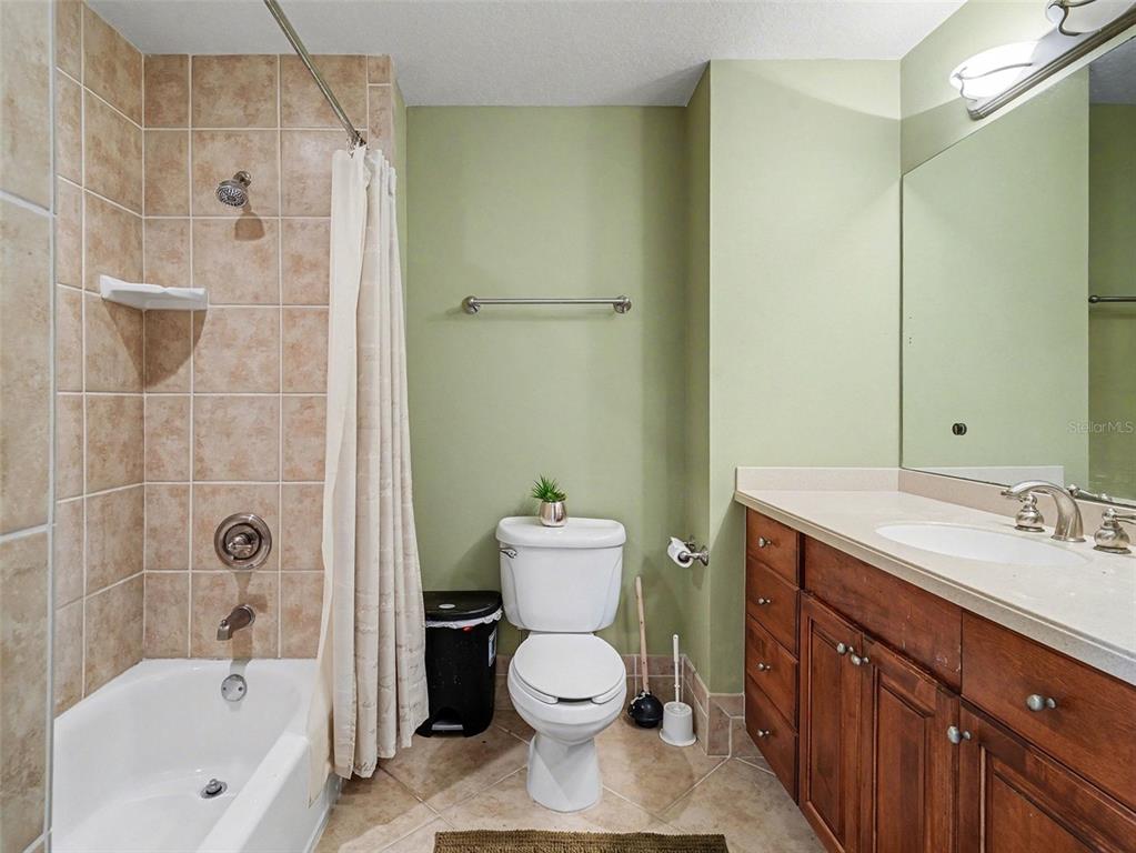 611 Riviera Dunes Way, Unit 102 Palmetto, FL 34221 - Photo 11 of 16 a bathroom with a sink toilet and shower