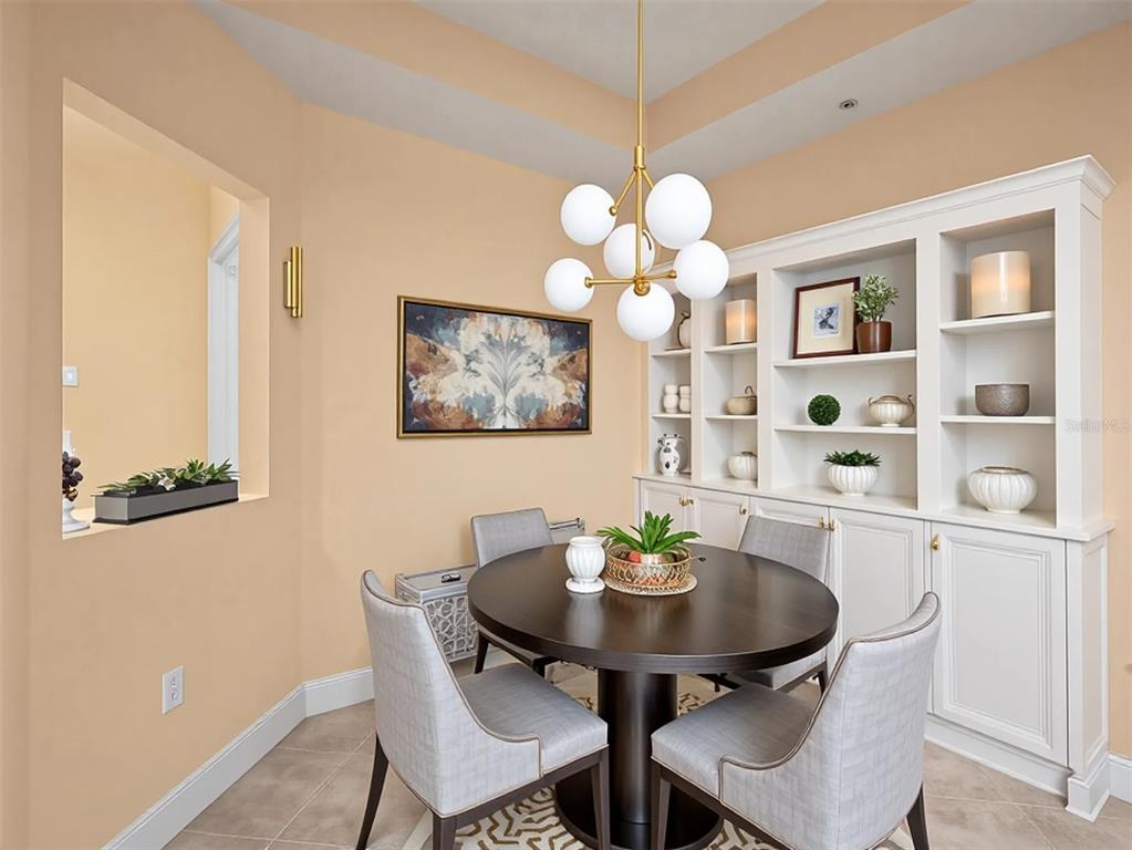 611 Riviera Dunes Way, Unit 102 Palmetto, FL 34221 - Photo 13 of 34 a view of a dining room with furniture and chandelier