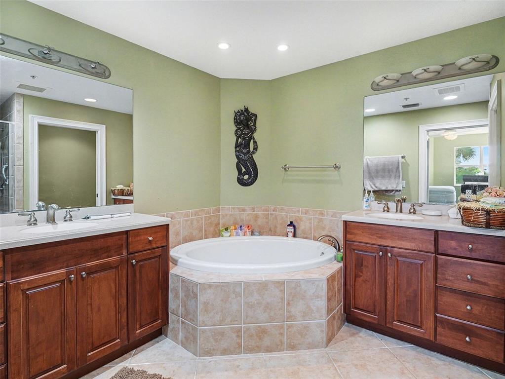 611 Riviera Dunes Way, Unit 102 Palmetto, FL 34221 - Photo 19 of 34 a spacious bathroom with a tub sink and mirror
