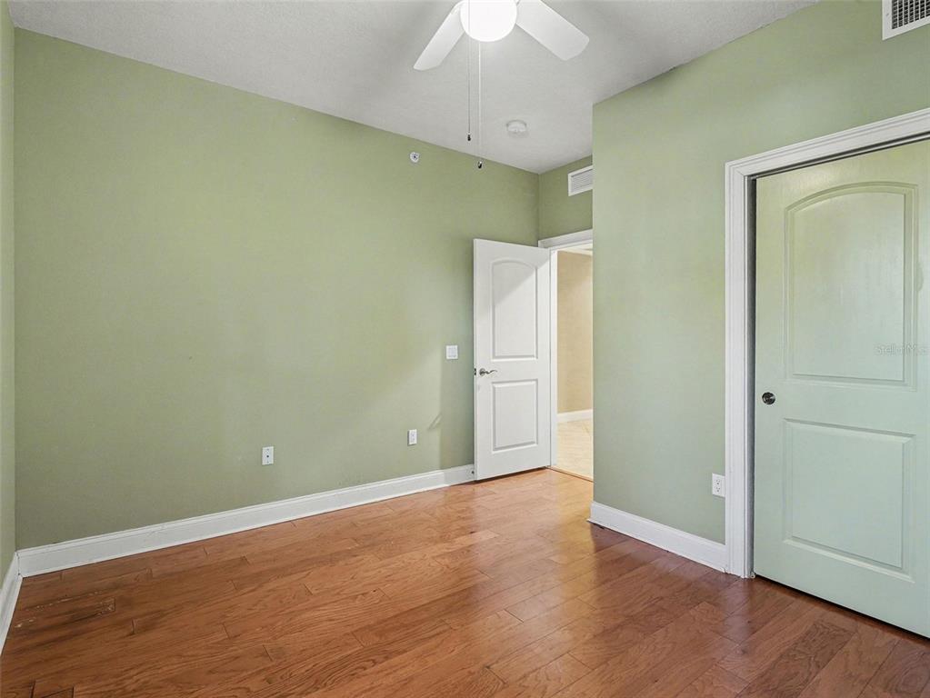 611 Riviera Dunes Way, Unit 102 Palmetto, FL 34221 - Photo 22 of 34 an empty room with wooden floor and a ceiling fan