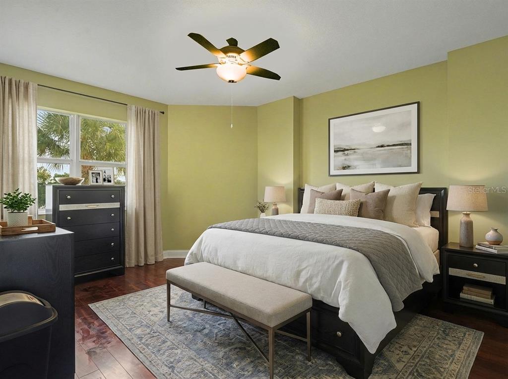 611 Riviera Dunes Way, Unit 102 Palmetto, FL 34221 - Photo 24 of 34 a bedroom with a bed and wooden floor