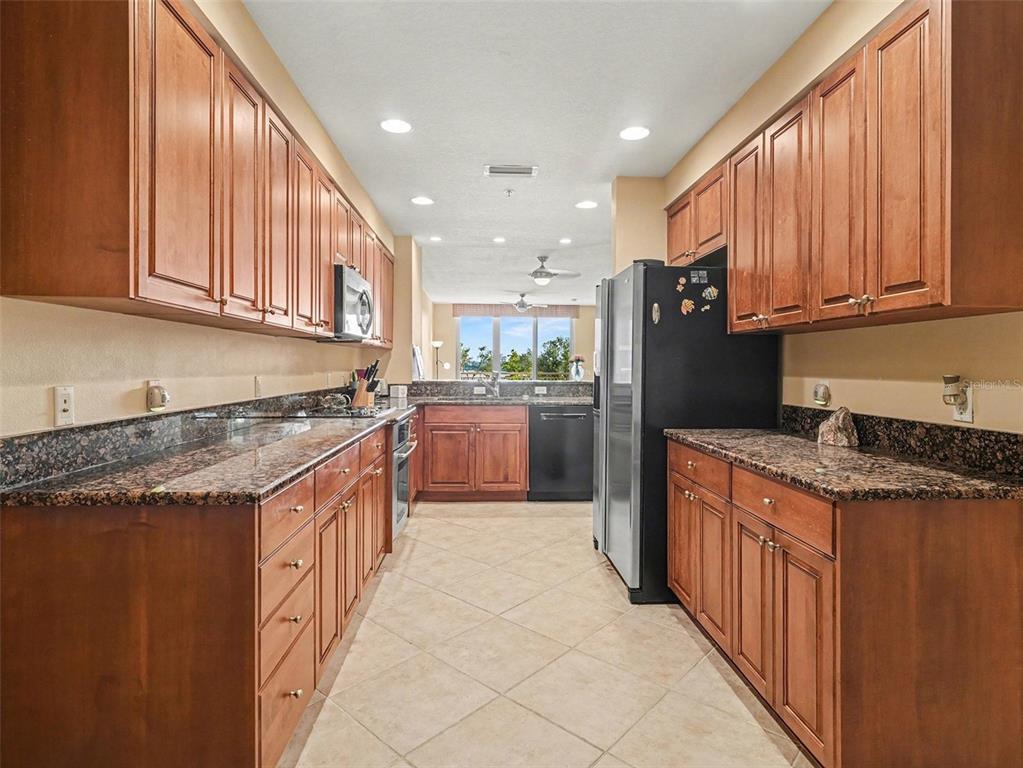 611 Riviera Dunes Way, Unit 102 Palmetto, FL 34221 - Photo 4 of 16 a kitchen with stainless steel appliances granite countertop a stove a sink dishwasher and a refrigerator