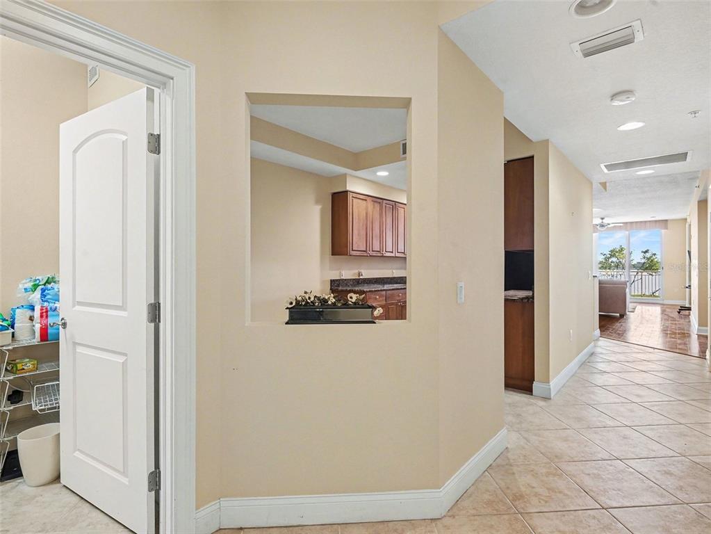 611 Riviera Dunes Way, Unit 102 Palmetto, FL 34221 - Photo 4 of 34 a view of a hallway with kitchen and dining area