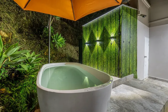 a bedroom with a bed and a flat tv screen on dresser