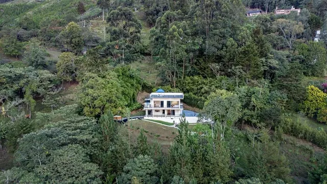 an aerial view of a house with swimming pool and garden view