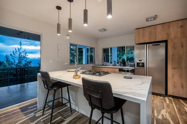 a kitchen with stainless steel appliances kitchen island granite countertop a dining table chairs and granite counter tops