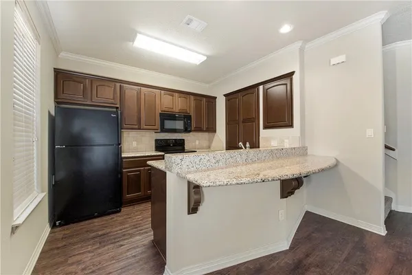 a kitchen with stainless steel appliances granite countertop a refrigerator and a stove top oven