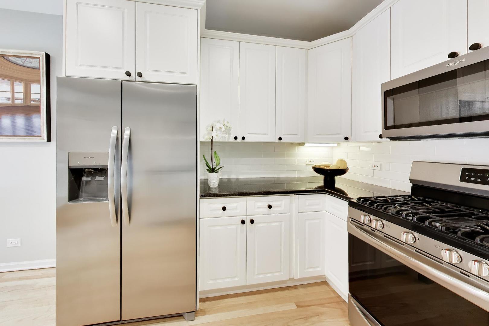 232 West Scott Street Chicago, IL 60610 - Photo 7 of 39 a kitchen with stainless steel appliances a refrigerator a stove and white cabinets