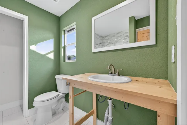 a bathroom with a toilet a sink and a mirror