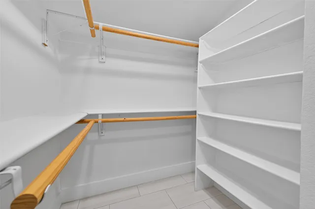 a view of walk in closet with empty racks