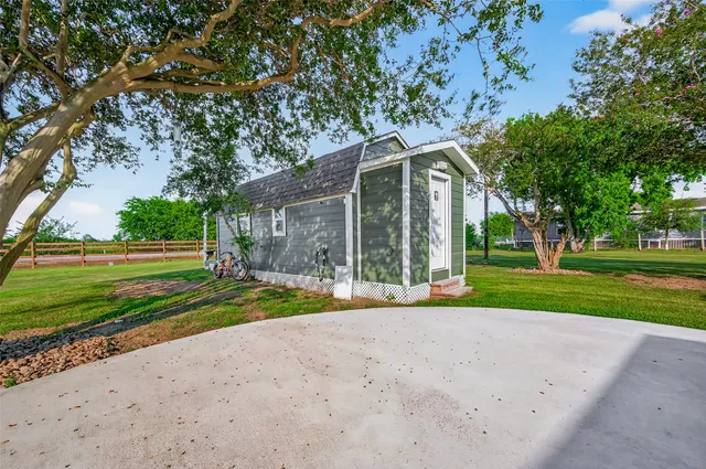 a view of a house with a big yard and large trees