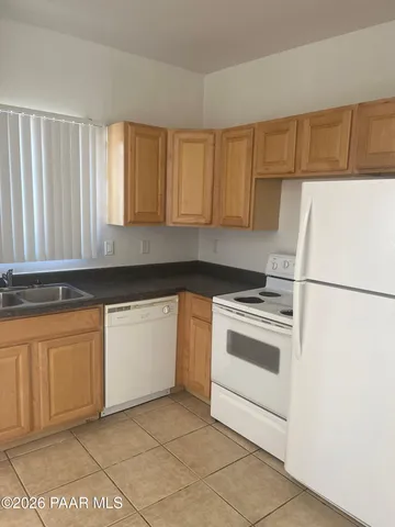 a kitchen with granite countertop white cabinets and white appliances