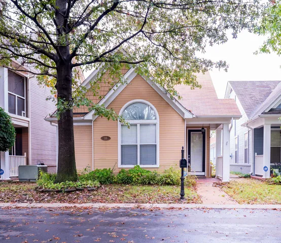 a front view of a house with garden and tress