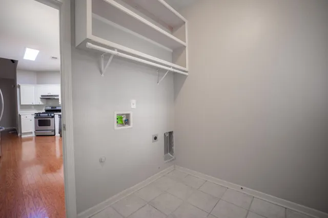 a view of a hallway with wooden floor and a kitchen