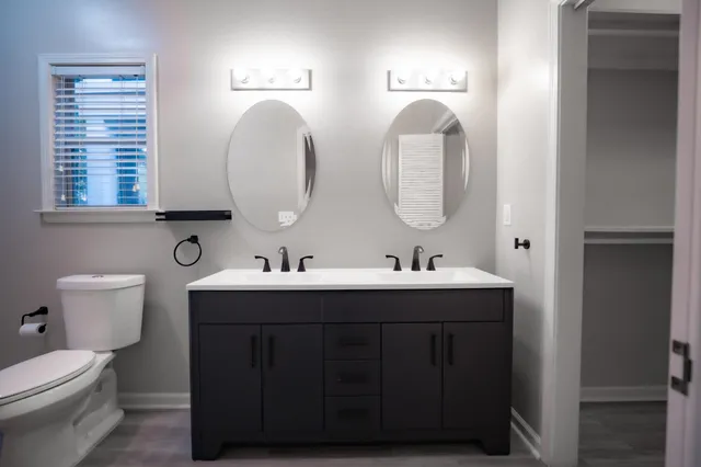 a bathroom with a toilet sink and mirror
