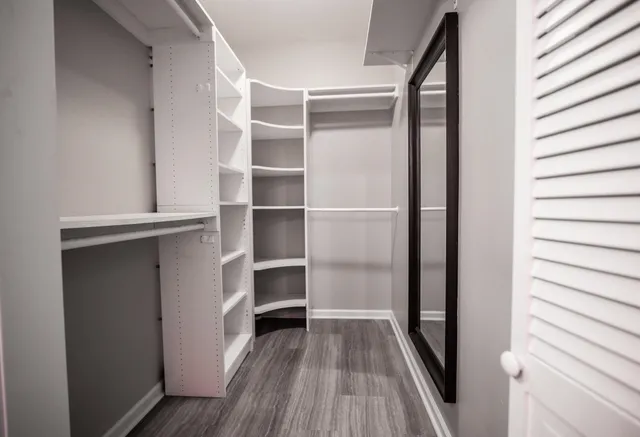 a view of walk in closet with empty racks