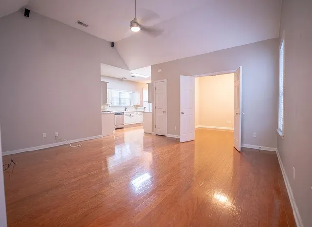 a view of a kitchen with a fridge and wooden floor
