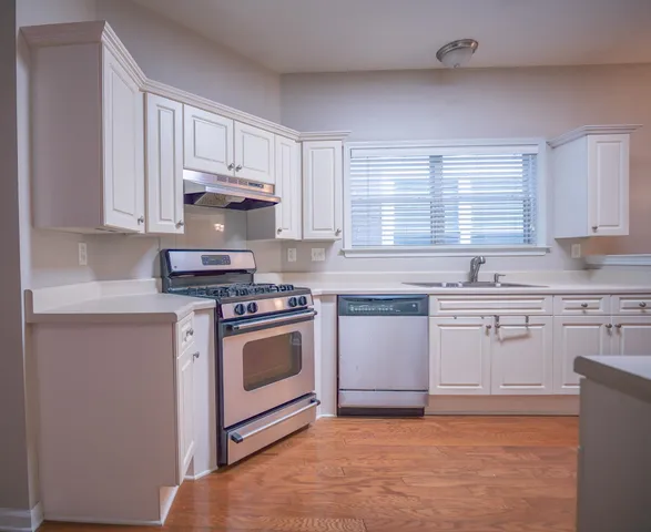 a kitchen with stainless steel appliances granite countertop a stove a sink and a microwave