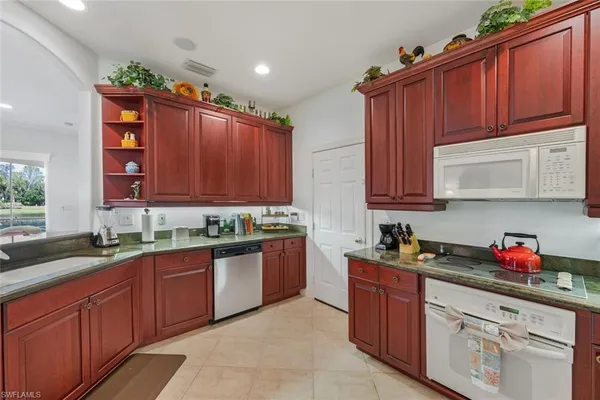 a kitchen with stainless steel appliances granite countertop a sink dishwasher stove and cabinets with wooden floor
