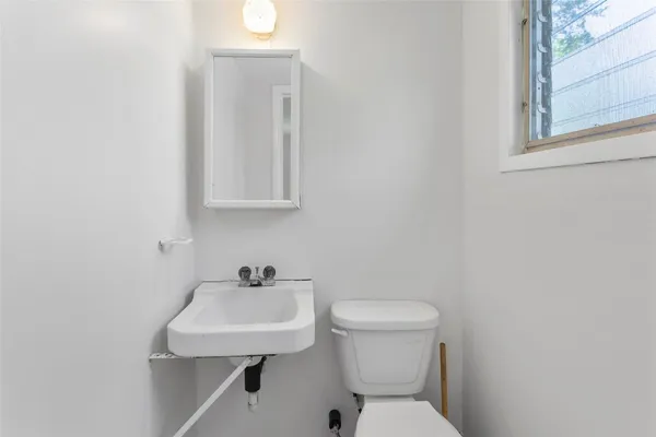 a bathroom with a toilet a sink and mirror