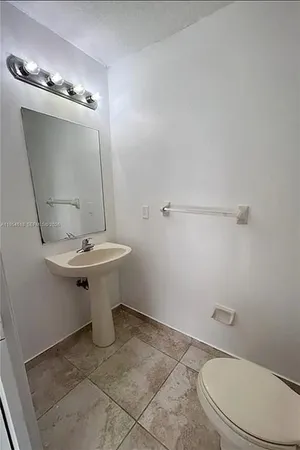 a bathroom with a sink a toilet and mirror