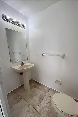 a bathroom with a sink a toilet and mirror