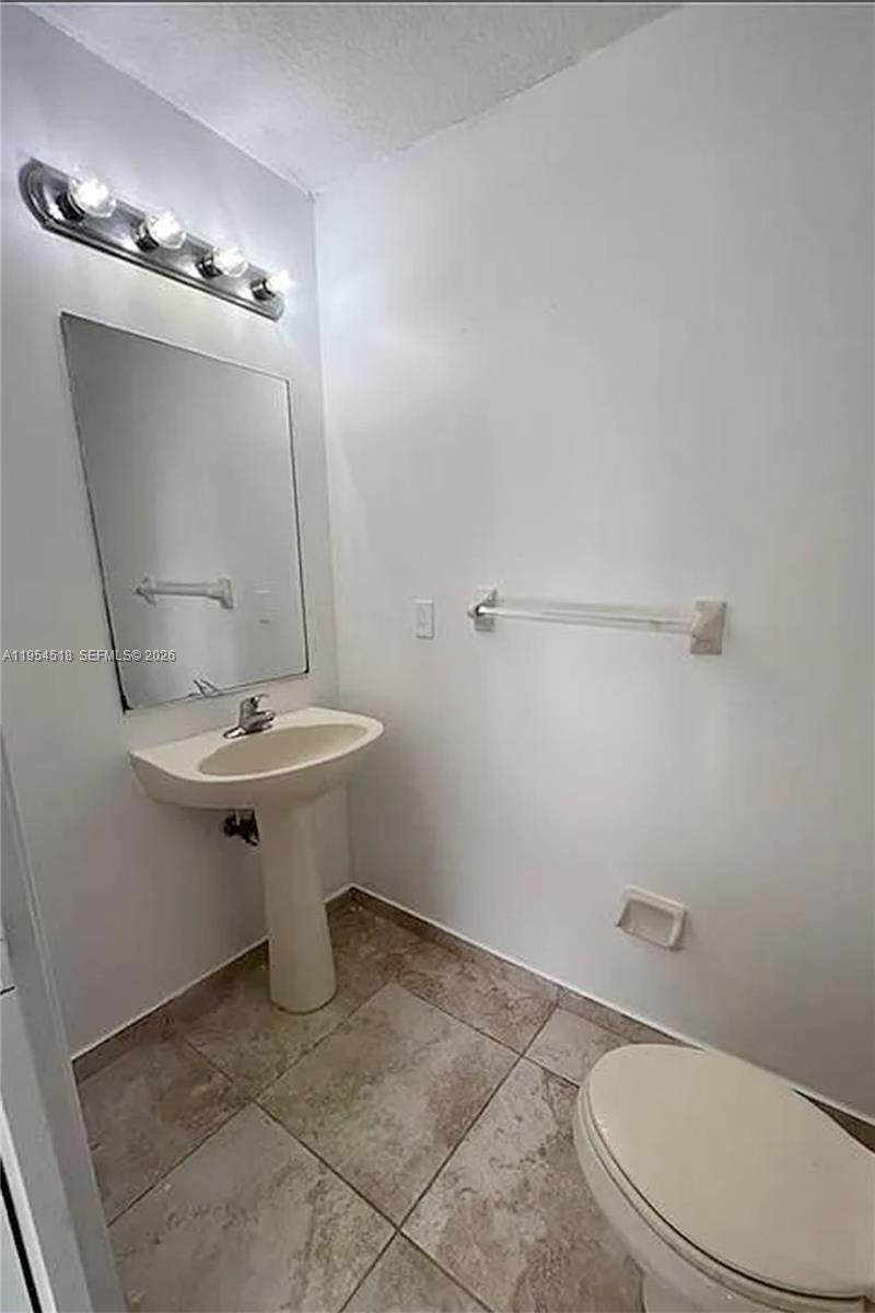 13990 Southwest 260th Street, Unit 13990 Homestead, FL 33032 - Photo 12 of 33 a bathroom with a sink a toilet and mirror