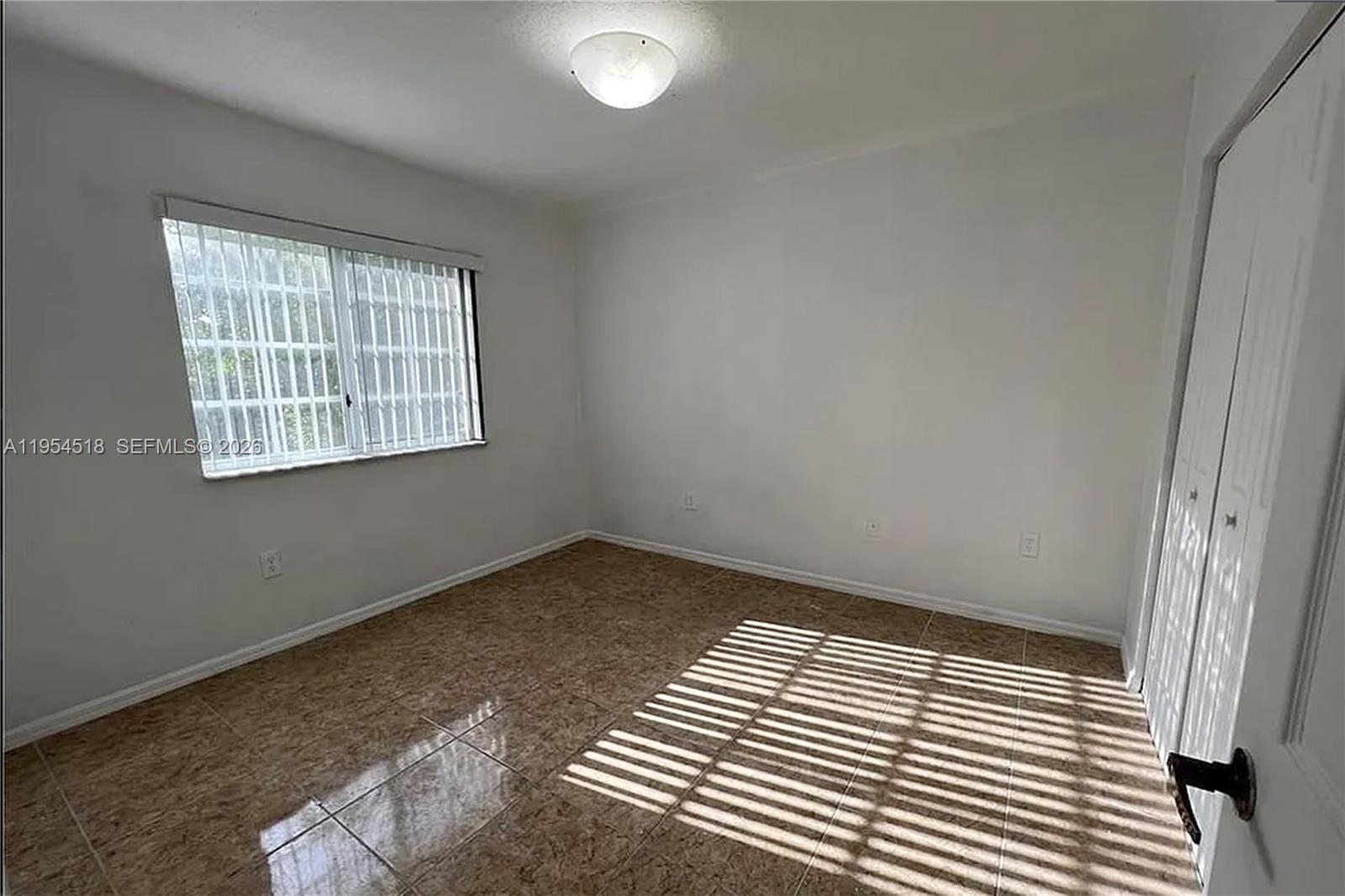 13990 Southwest 260th Street, Unit 13990 Homestead, FL 33032 - Photo 17 of 33 an empty room with wooden floor and windows