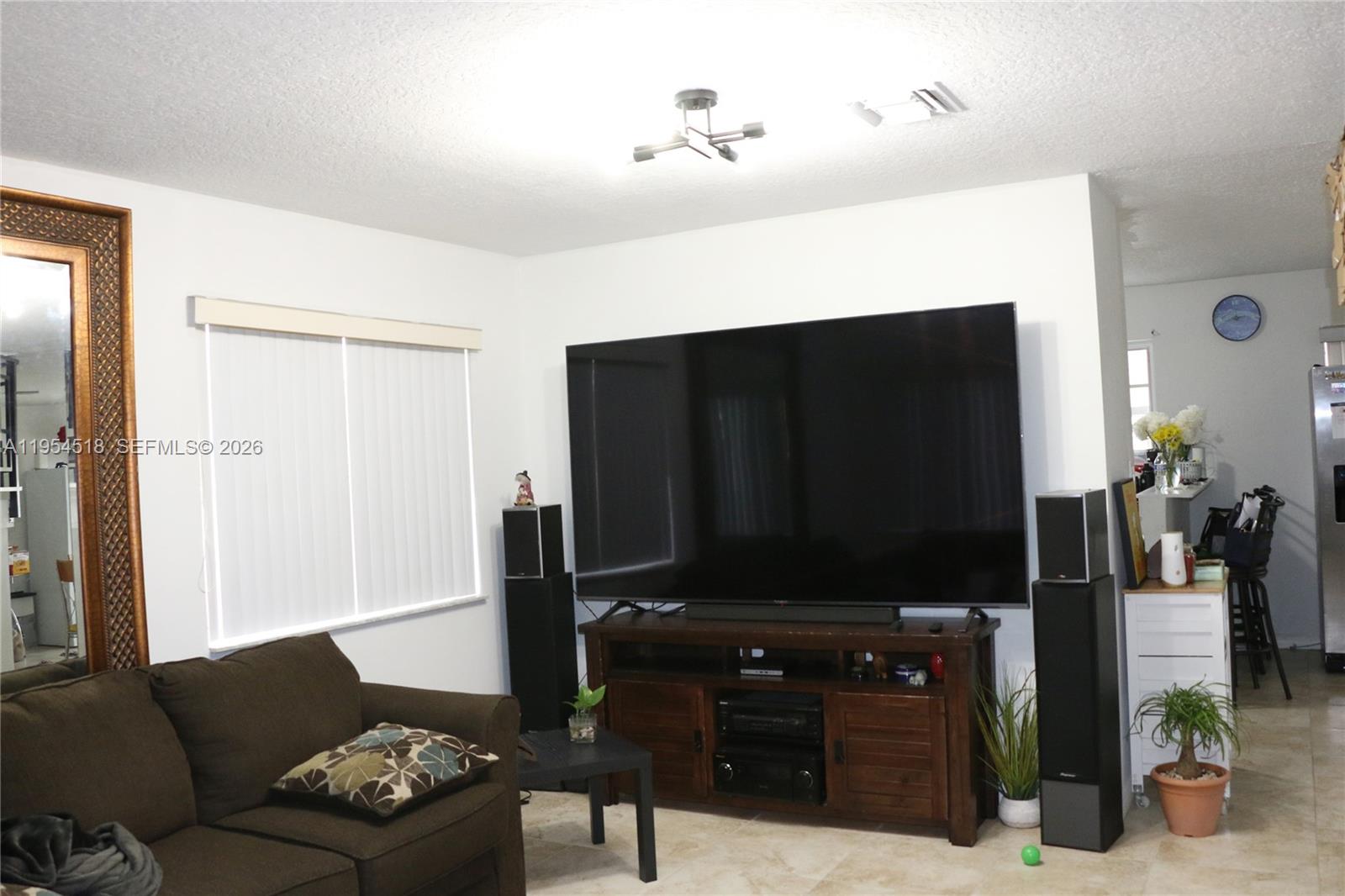 13990 Southwest 260th Street, Unit 13990 Homestead, FL 33032 - Photo 24 of 33 a living room with furniture and a flat screen tv